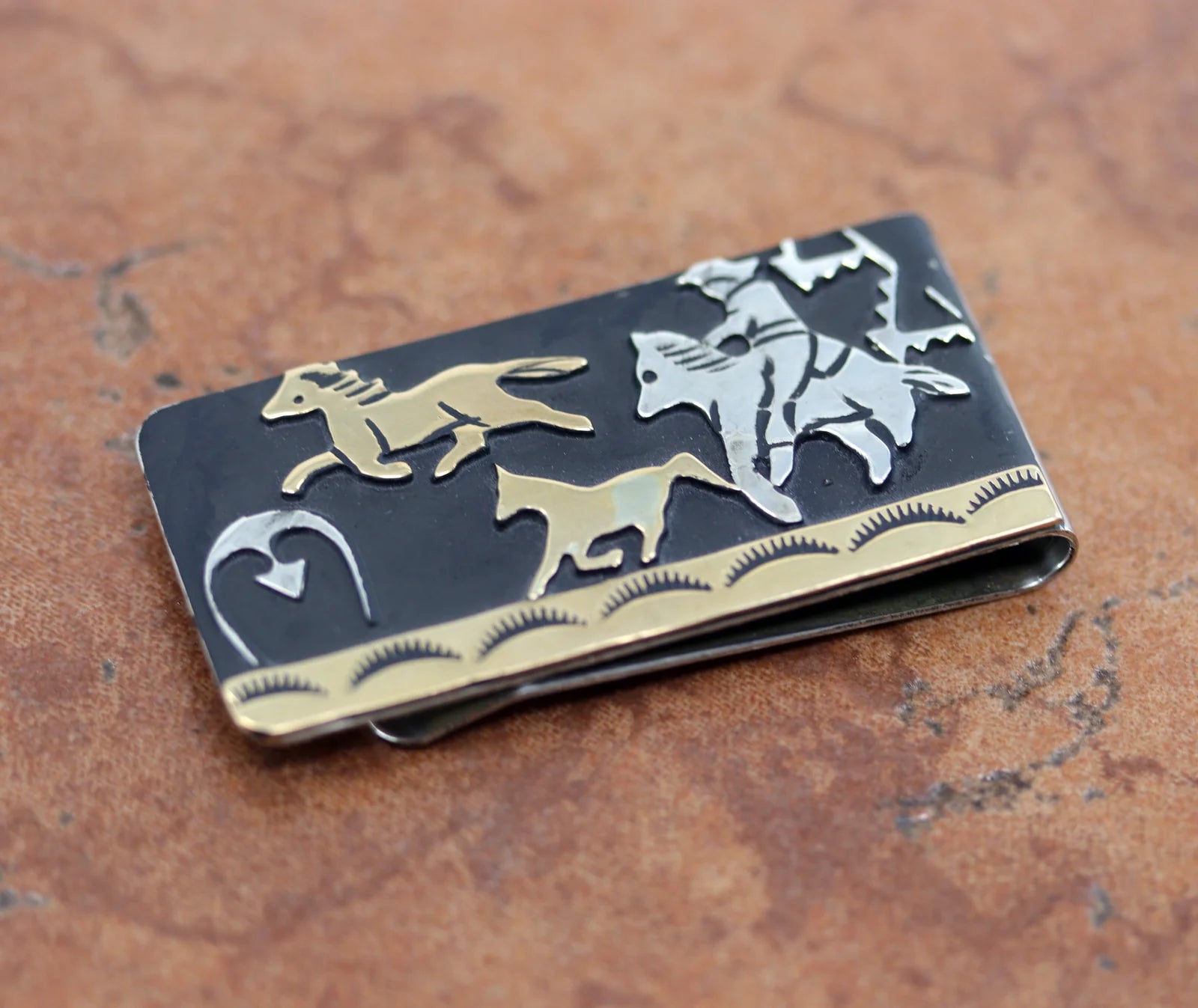 Mostly black money clip with a gold overlay trim and gold overlay and silver horses