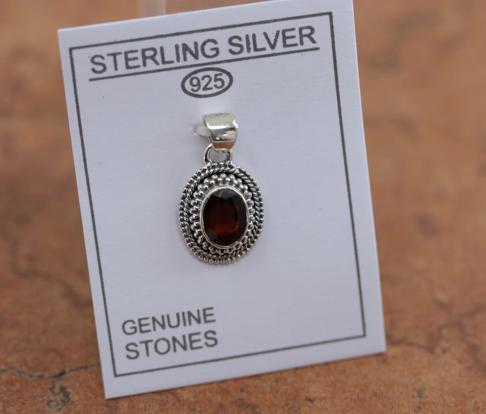 Silver circular Pendant with a red garnet gemstone in the center