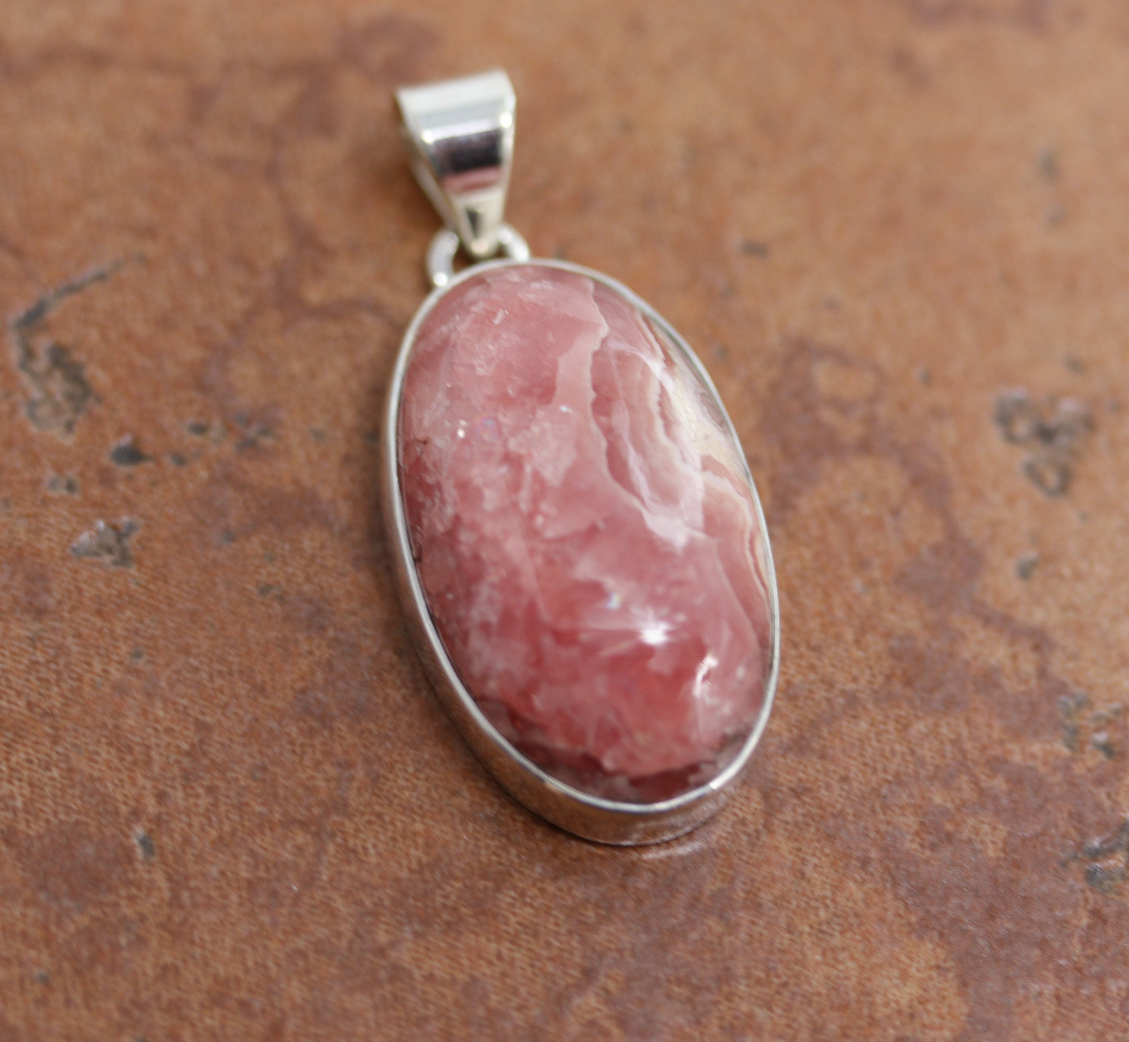 Large oval shaped pendant made from pink quartz with a silver bail