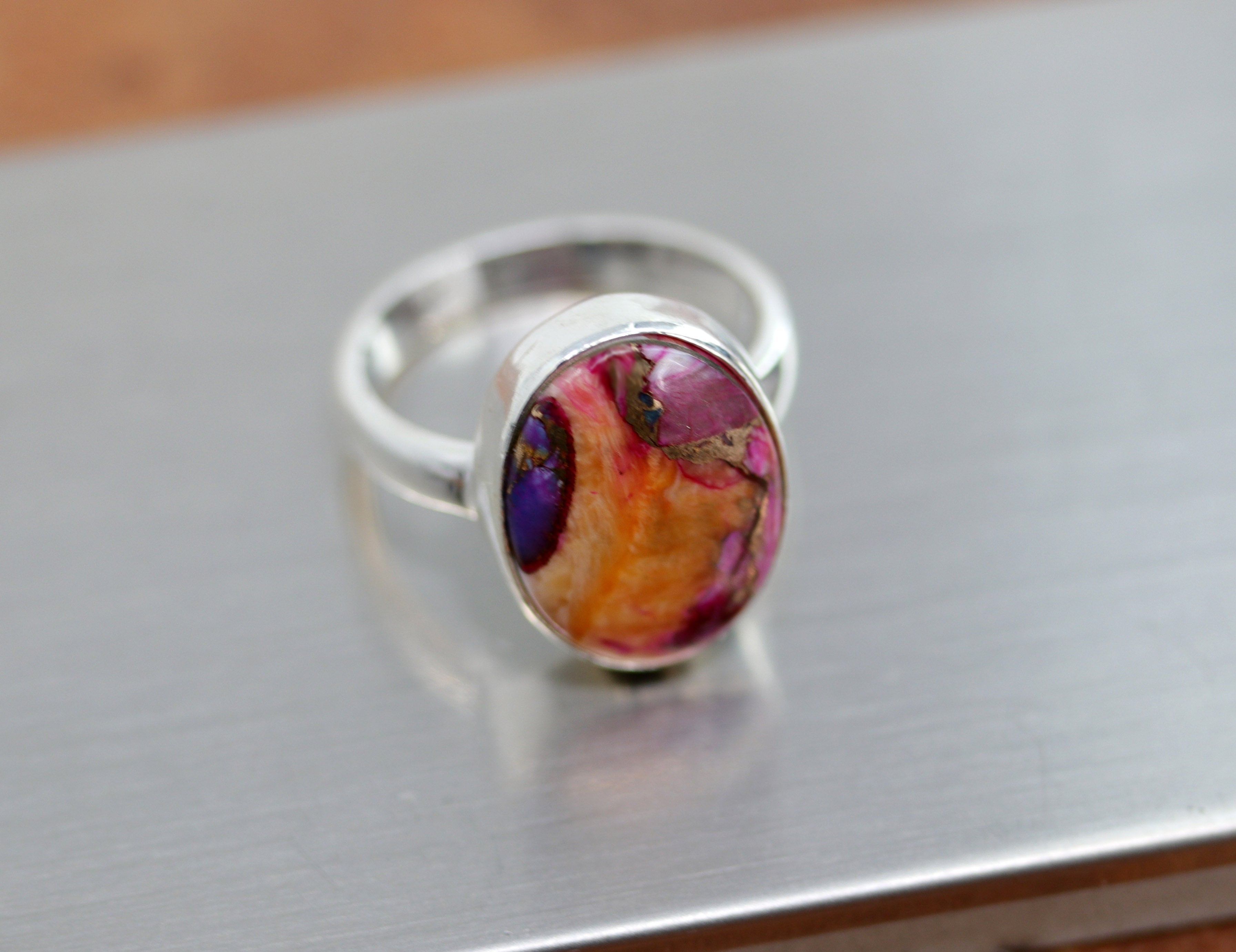 Silver Ring with a multi color circular  mojave turquoise gemstone that is mostly orange with bits of blue and pink