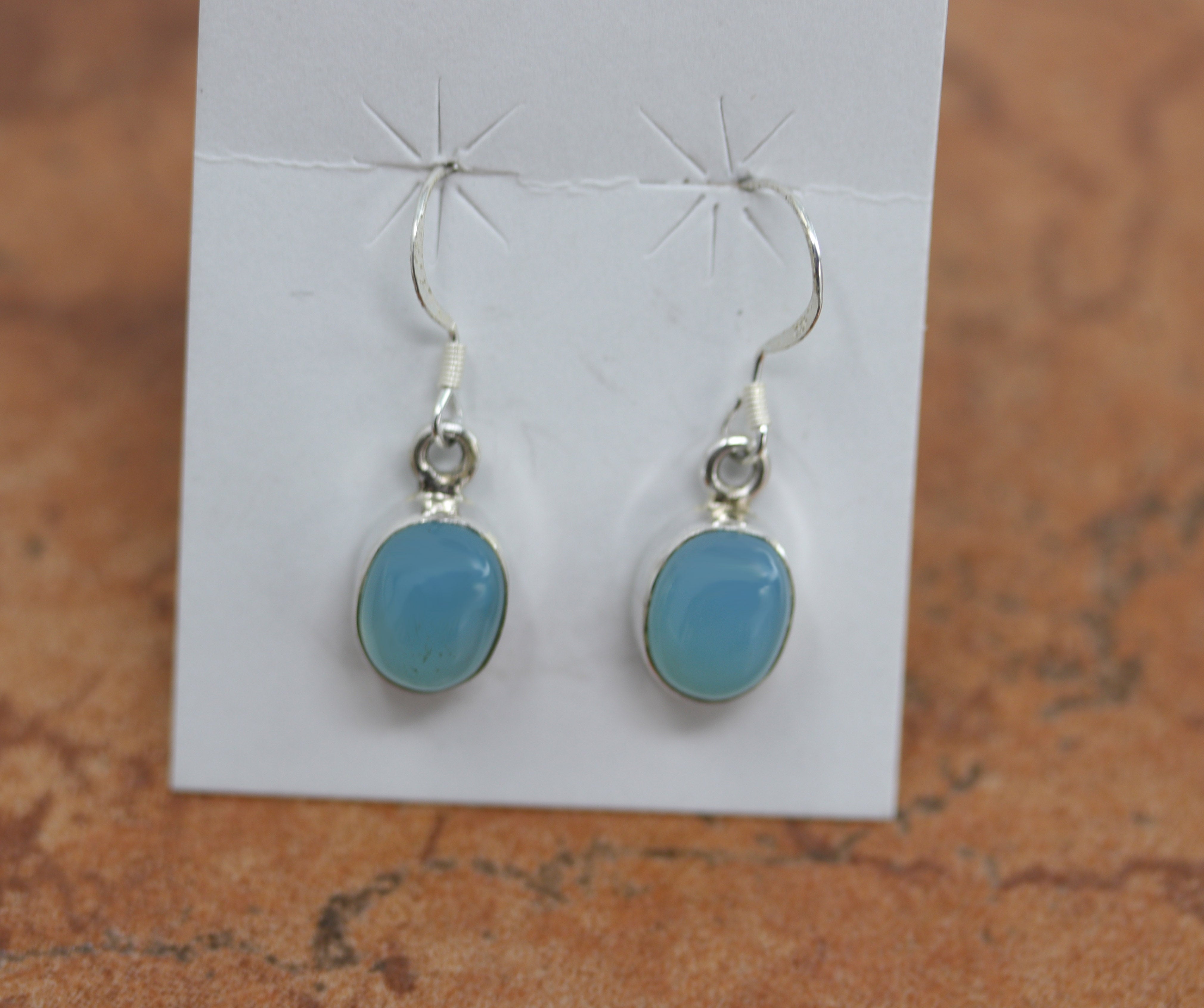 Silver earrings with circular baby blue colored chalcedony gemstones